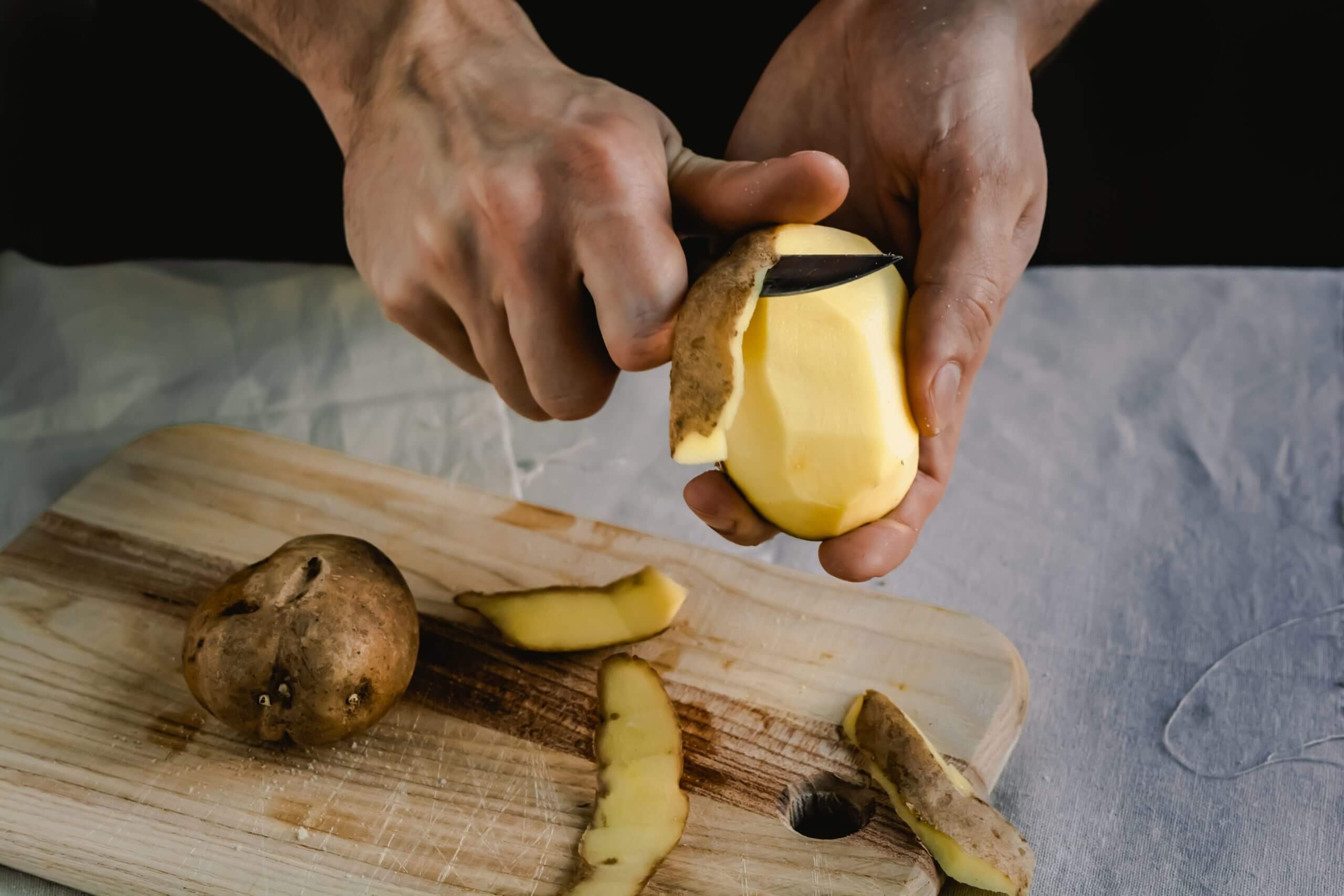 https://www.escoffieronline.com/wp-content/uploads/2020/06/Chef-peeling-potatoes-on-wooden-cutting-board-1-scaled.jpeg